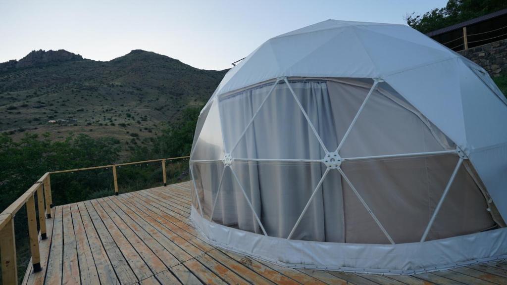 a tent on a deck with mountains in the background at Glamping Yeghegis in Yeghegis