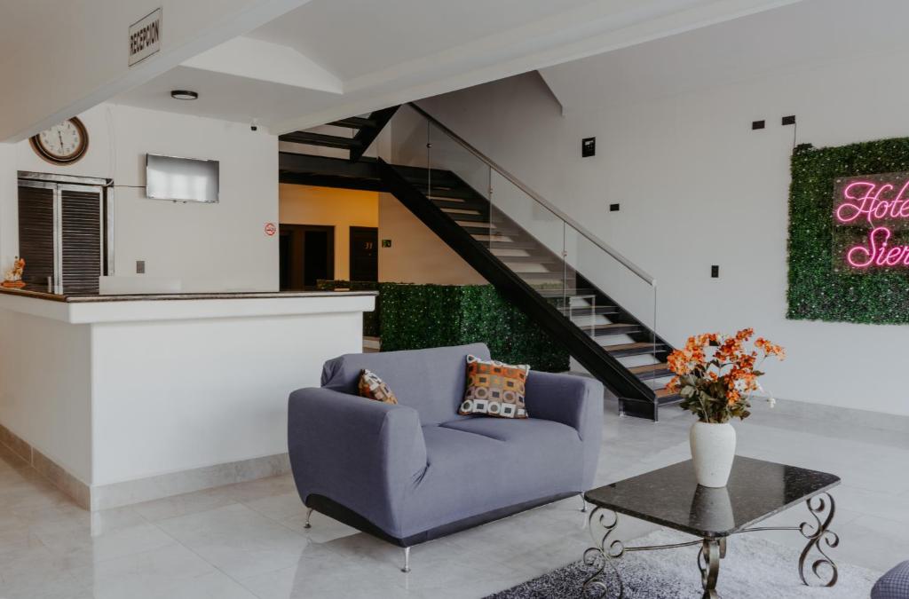 a living room with a blue couch and a table at Hotel sierra palace in Cuauhtémoc