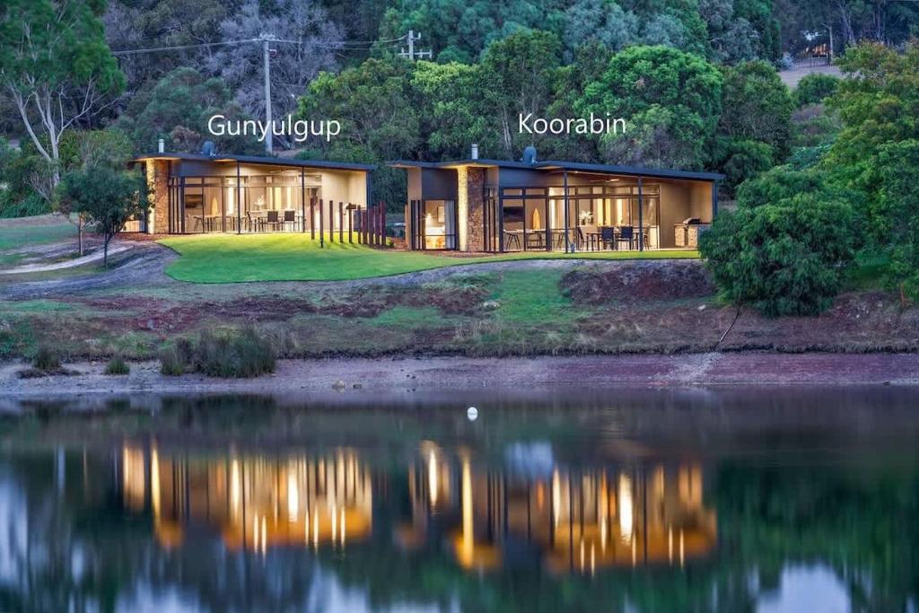 a house on a hill next to a lake at Artisan Koorabin - Lakeside Luxe Retreat next to Spa in Yallingup
