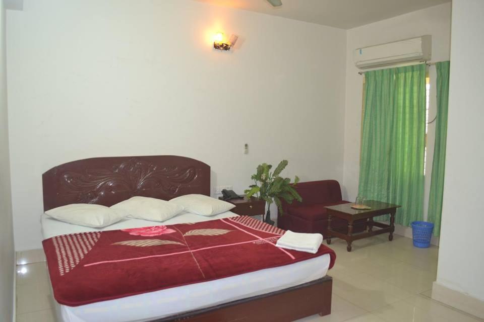 a bedroom with a large bed with a red blanket at Hotel Shams Plaza in Cox's Bazar