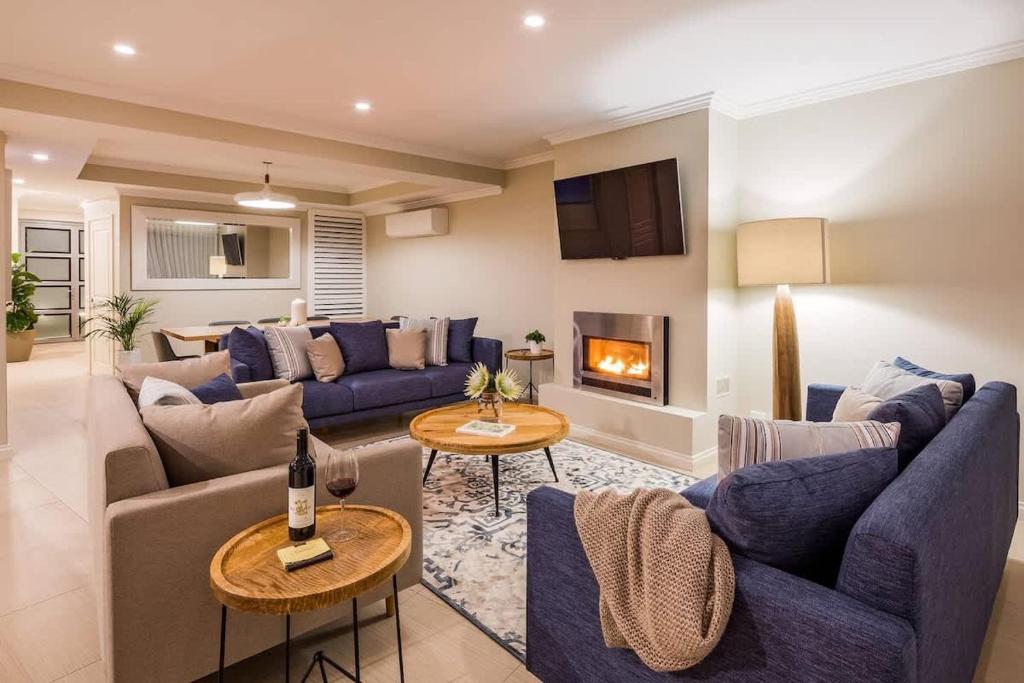 a living room with blue couches and a fireplace at 'Azure' Beachside Resort Escape for Groups in Marybrook