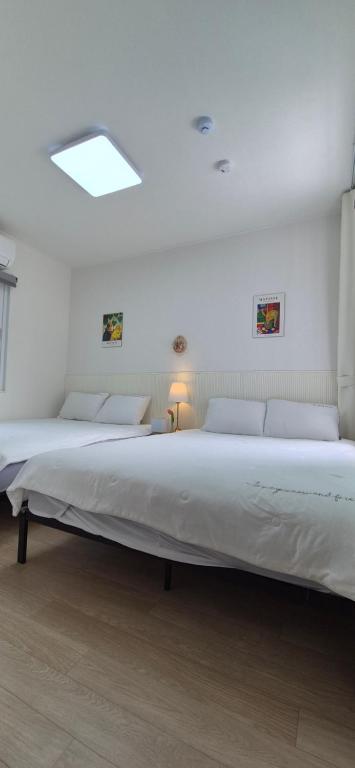 two beds in a room with a large bed at 1&2stayㅡH in Tongdaegu-yŏk