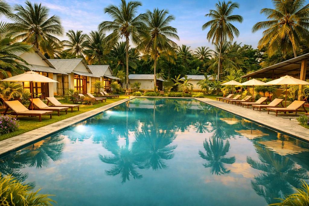 a pool at a resort with chairs and palm trees at Marina Safari Resort Udawalawe in Udawalawe