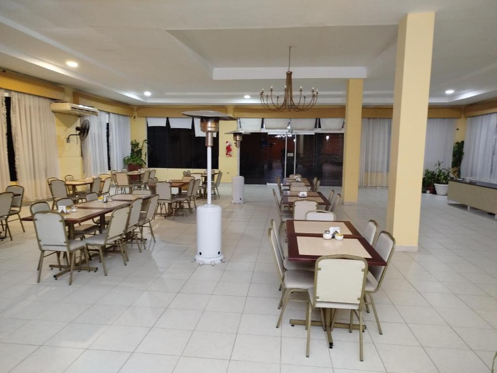 a restaurant with tables and chairs in a room at Hotel Don Oresttes in La Carrera