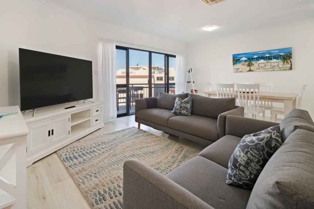 a living room with a couch and a flat screen tv at Riverfront 2BR Apt with Views, Balcony & Parking in Maroochydore