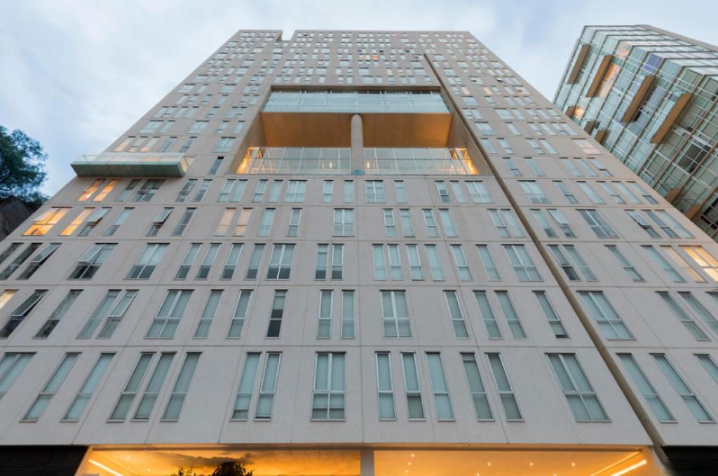 a tall white building with many windows at QBICo Santa Fe Condominium in Mexico City