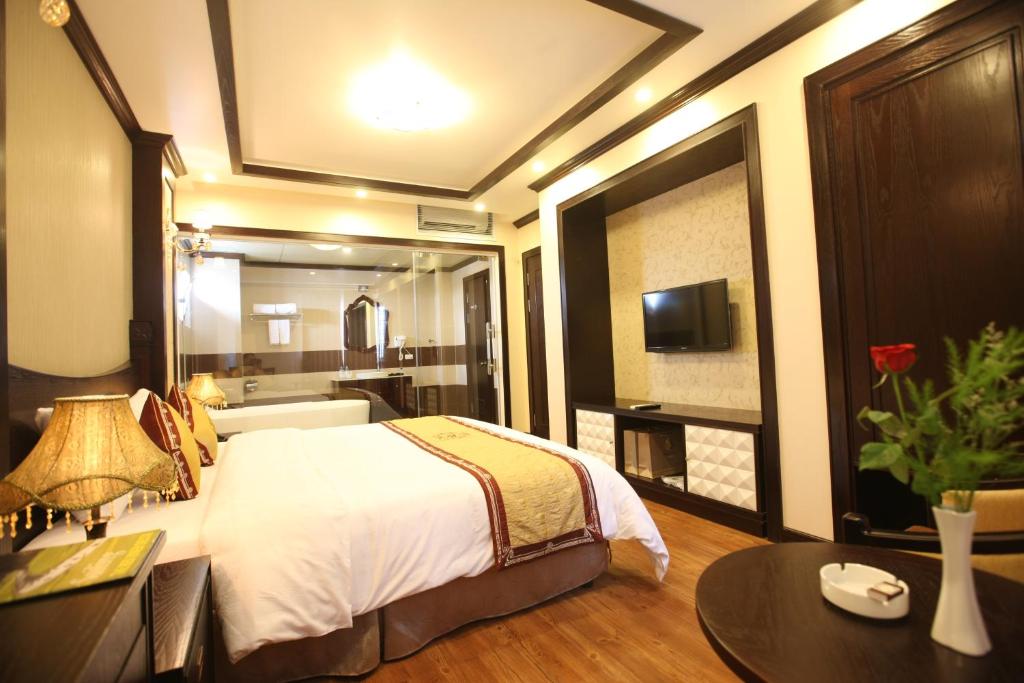 a bedroom with a bed and a desk and a tv at Lac Long Hotel Hai Phong in Hai Phong