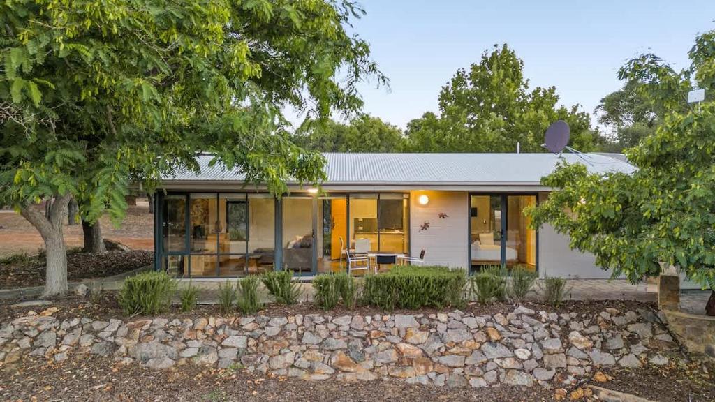 a white house with glass doors and a stone yard at Petra Olive 2 in Yallingup