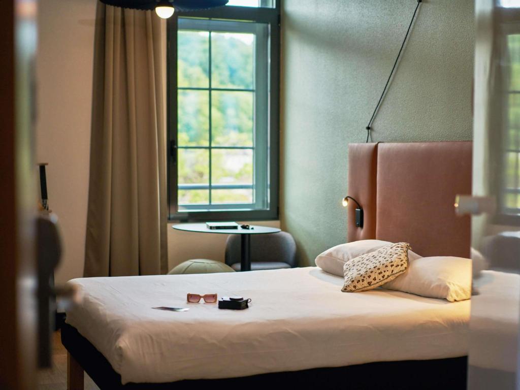 a hotel room with a bed with a window at Ibis Sarlat Centre in Sarlat-la-Canéda