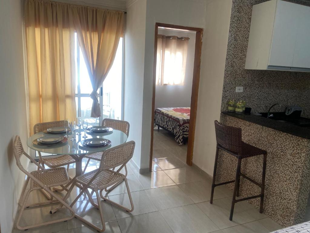 a dining room with a table and chairs and a kitchen at Prive Familiar e Aconchegante in Paulista
