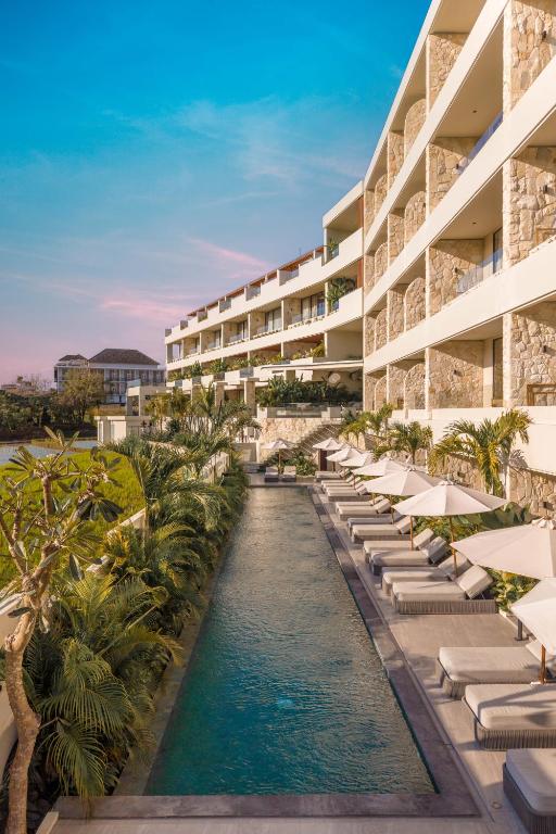 an external view of a resort with a pool and lounge chairs at Sore Escape Tumbak Bayuh by Betterplace in Canggu