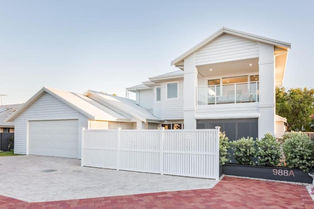 a house with a white fence in front of it at Fernweh - A Generous Hamptons-style Beachside Escape in Geographe