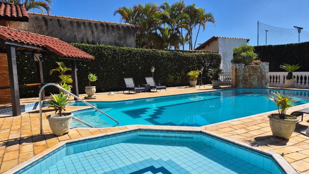 a swimming pool with plants in a house at Chácara em Boituva-SP com piscina e churrasqueira in Boituva