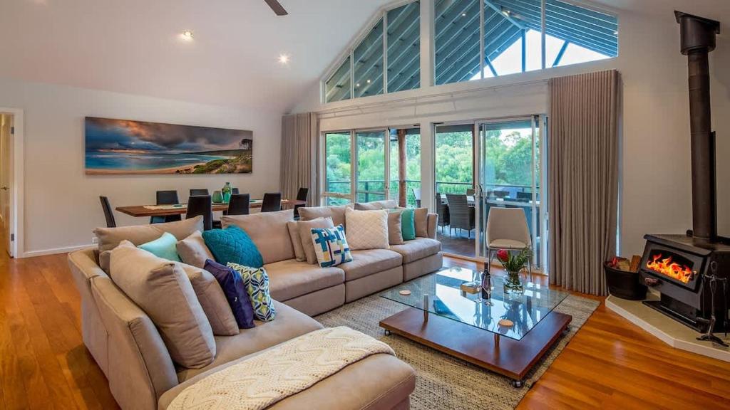 a living room with a couch and a fireplace at Sky View - Elevated Estate with Resort-Style Pool in Yallingup