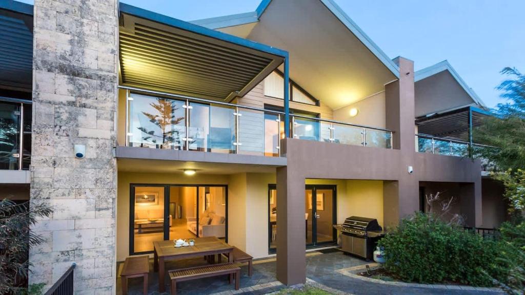 a house with a picnic table in front of it at Surfside 8 - Spacious Retreat on Yallingup Beach in Yallingup