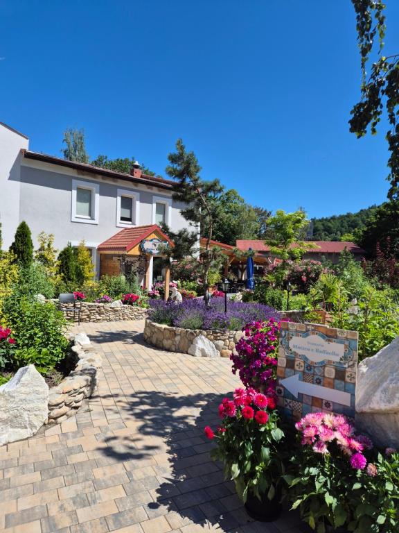 a garden with flowers in front of a house at Apartamenty Amadeus & Trattoria Matteo e Raffaello in Stronie Śląskie