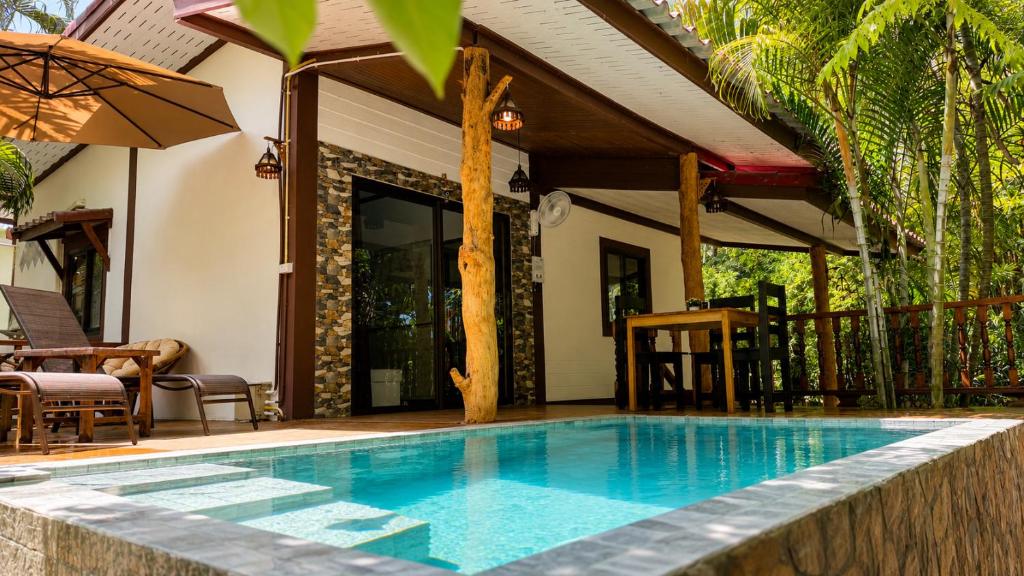 a swimming pool in front of a house at Zen Harmony Pool Villa in Ko Phangan