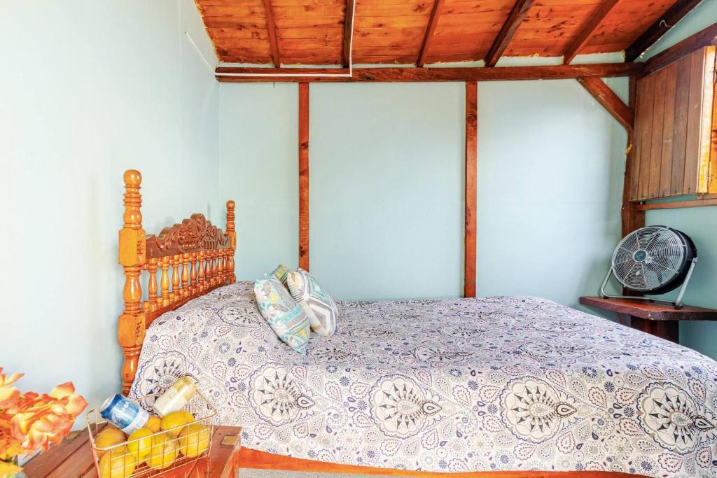 a bedroom with a bed with a wooden head board at Cabaa el Sol Medellin in Titiribí