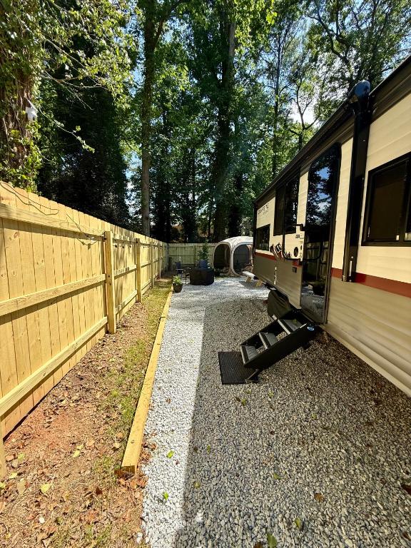 a train is parked next to a fence at Rest Up Retreat-New Lux RV-Private-6Flags-Fire Pit-Hammock-Atlanta in Atlanta
