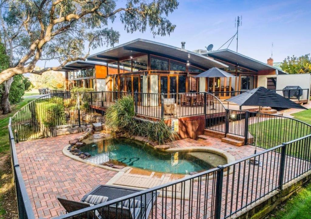 a house with a swimming pool in front of it at Elements - Echuca Holiday Homes in Moama