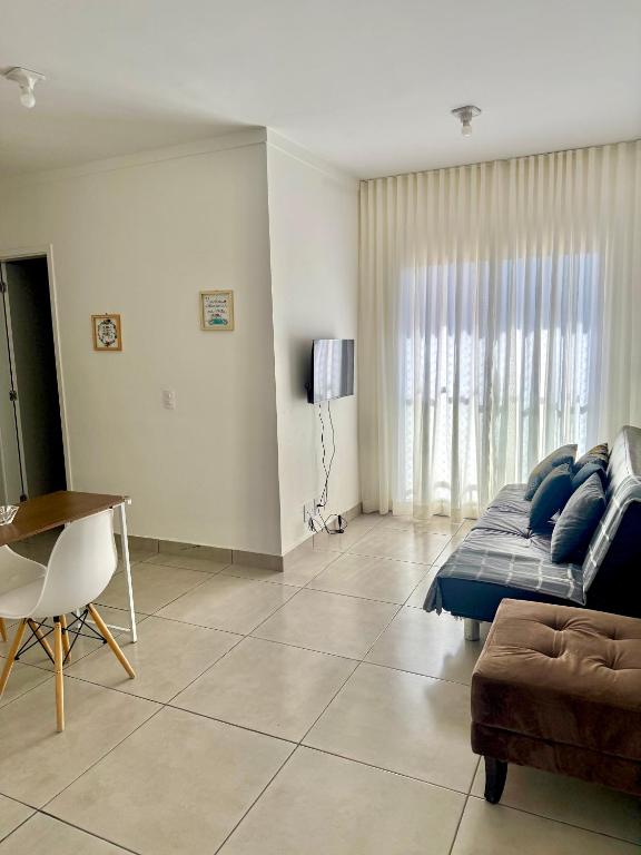a living room with a couch and a table at Lumar Apart Boituva Diária 24H in Boituva