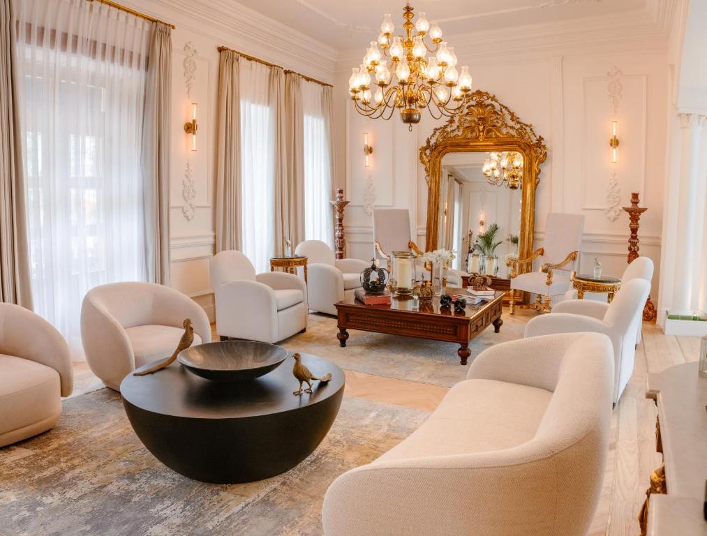 a living room with white furniture and a large mirror at Hotel Casa Huamantla in Huamantla