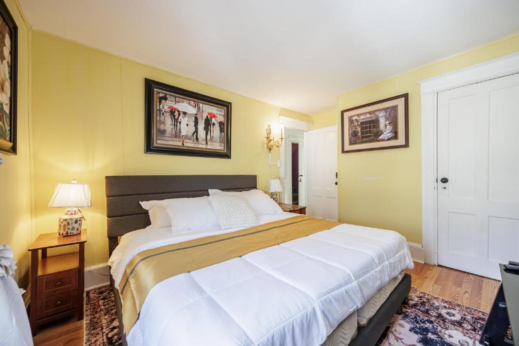 a bedroom with a large white bed and yellow walls at Room B2 Shared bathroom Kingbed washer dryer in Rochester