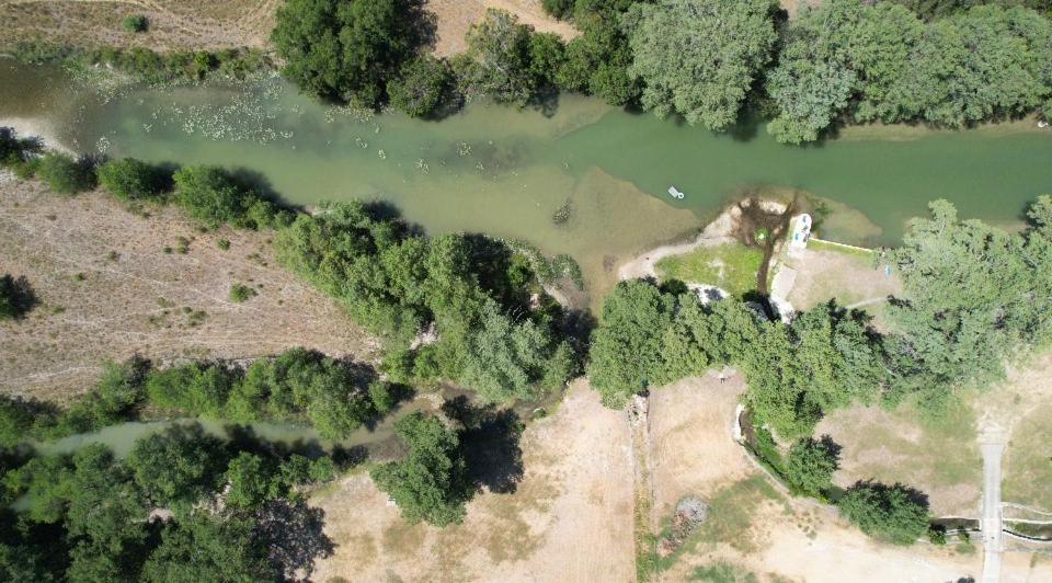 an aerial view of a river and trees at River Run Maggie's house in Kerrville