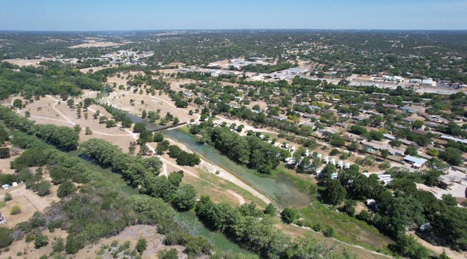 an aerial view of a park with trees and a river at River Run Retreat in Kerrville