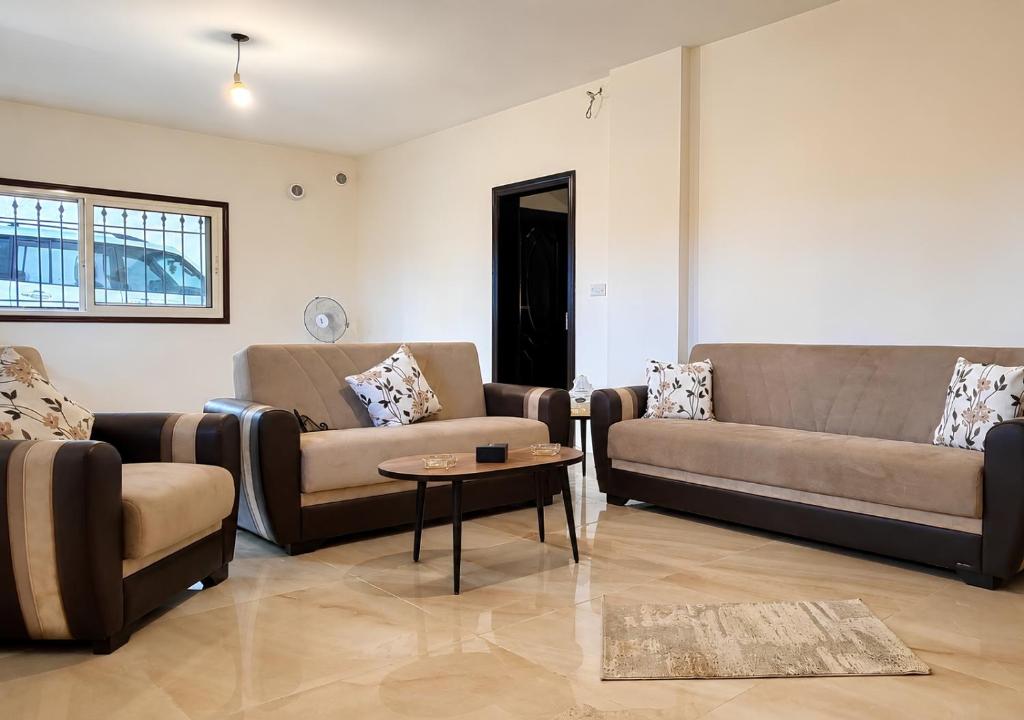 a living room with two couches and a table at Mountain Escape with Rooftop in Jūrat Arşūn