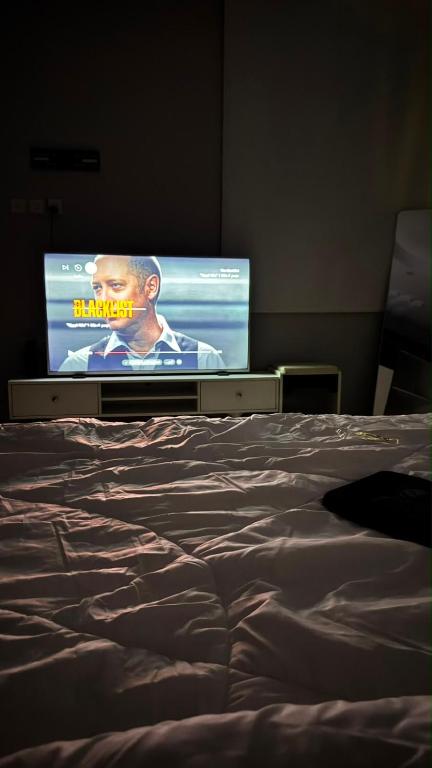 a bedroom with a bed with a tv in the background at بيّت الضيافة in Al Baha