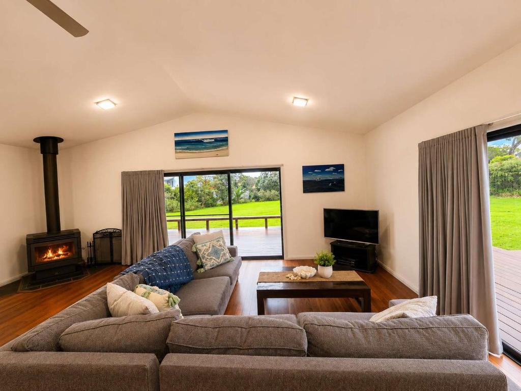 a living room with a couch and a fireplace at Bawley Backyard Haven - family retreat near beach in Bawley Point