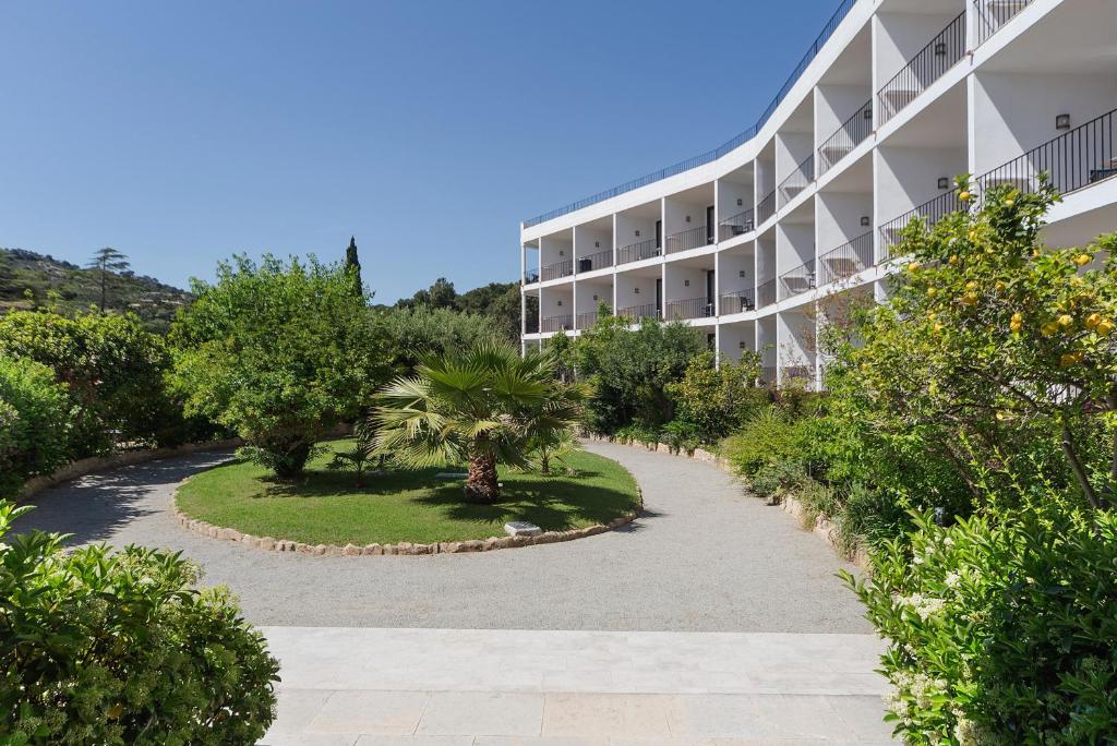 a building with a courtyard with trees and bushes at Hotel Eetu Begur, Affiliated by Meliá in Begur