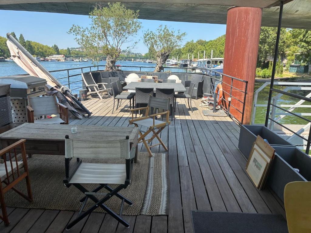 a deck with tables and chairs on a boat at Peniche Casa Luze in Issy-les-Moulineaux