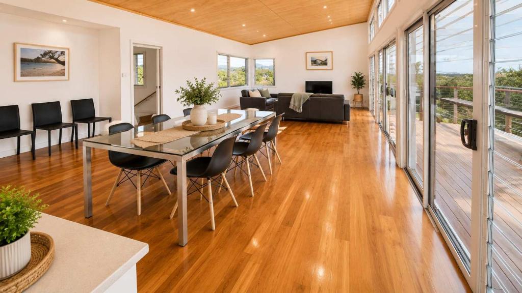 a dining room and living room with a table and chairs at Anchor at Bawley in Bawley Point