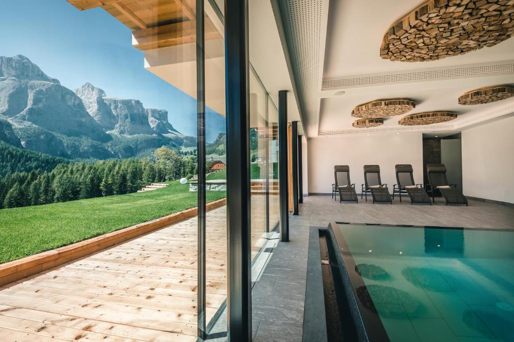 a house with a swimming pool and a view of mountains at Lüch de Costa in Colfosco