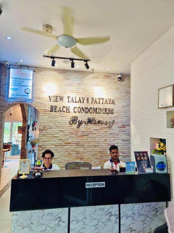 two men sitting at a counter in a restaurant at View Talay 6 Pattaya Beach Apartment by Honey in Pattaya
