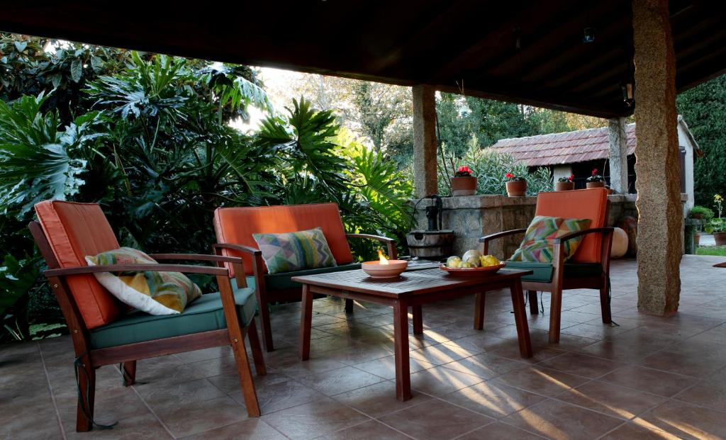 a patio with two chairs and a table with a table at Casa O Fabal in Fabal