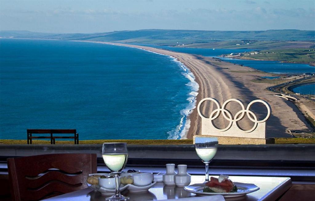 una mesa con dos copas de vino y vistas a los anillos olímpicos en Heights Hotel en Portland