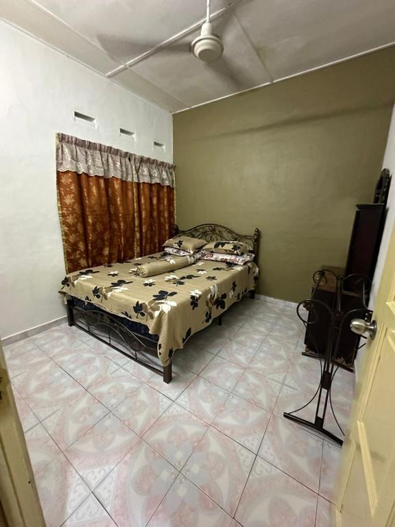 a bedroom with a bed and a television in it at Kannan homestay in Kamunting