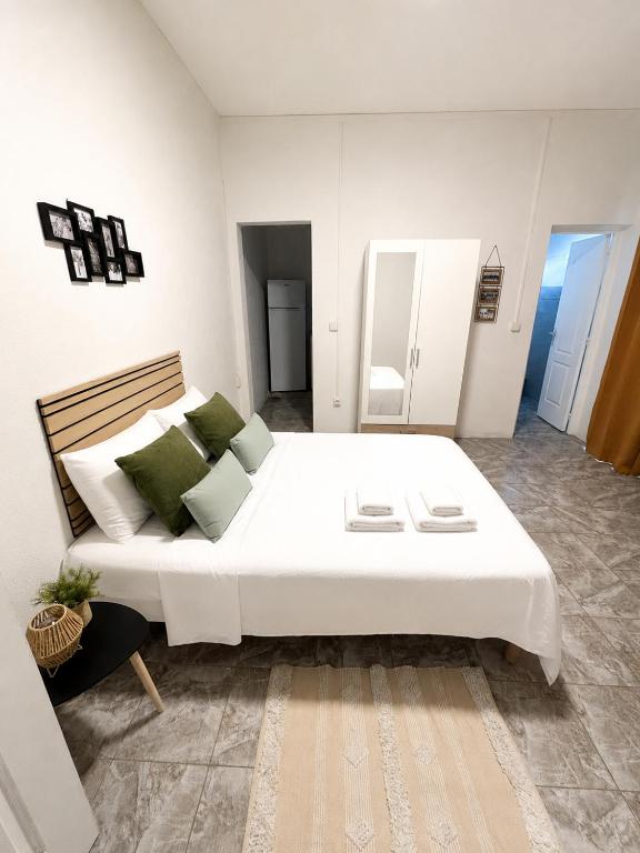 a bedroom with a large white bed and a couch at Harmony Caraibes in Le Robert