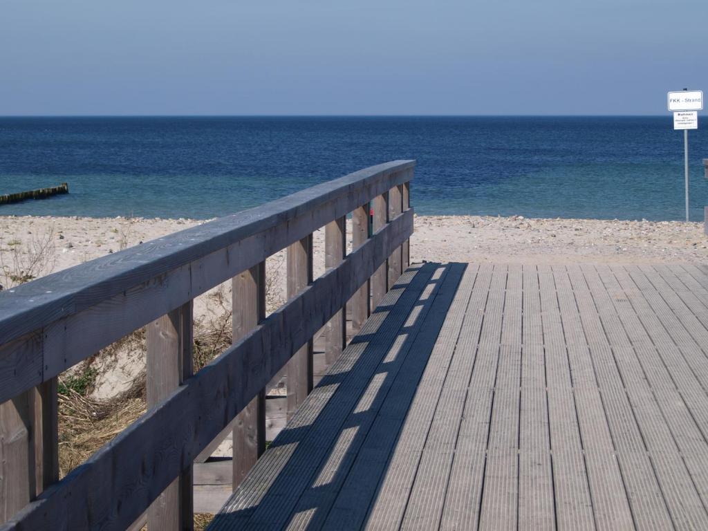 a wooden boardwalk leading to a beach with the ocean at Ferienwohnung Strandläufer in Börgerende-Rethwisch