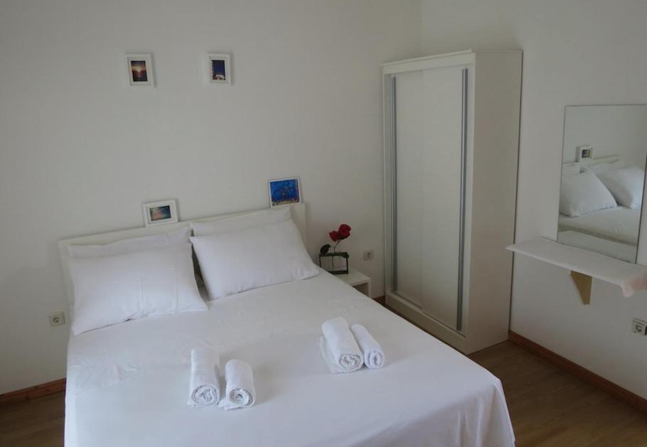 una camera da letto con un letto bianco e due pantofole sopra di SD House Rooms a Bol