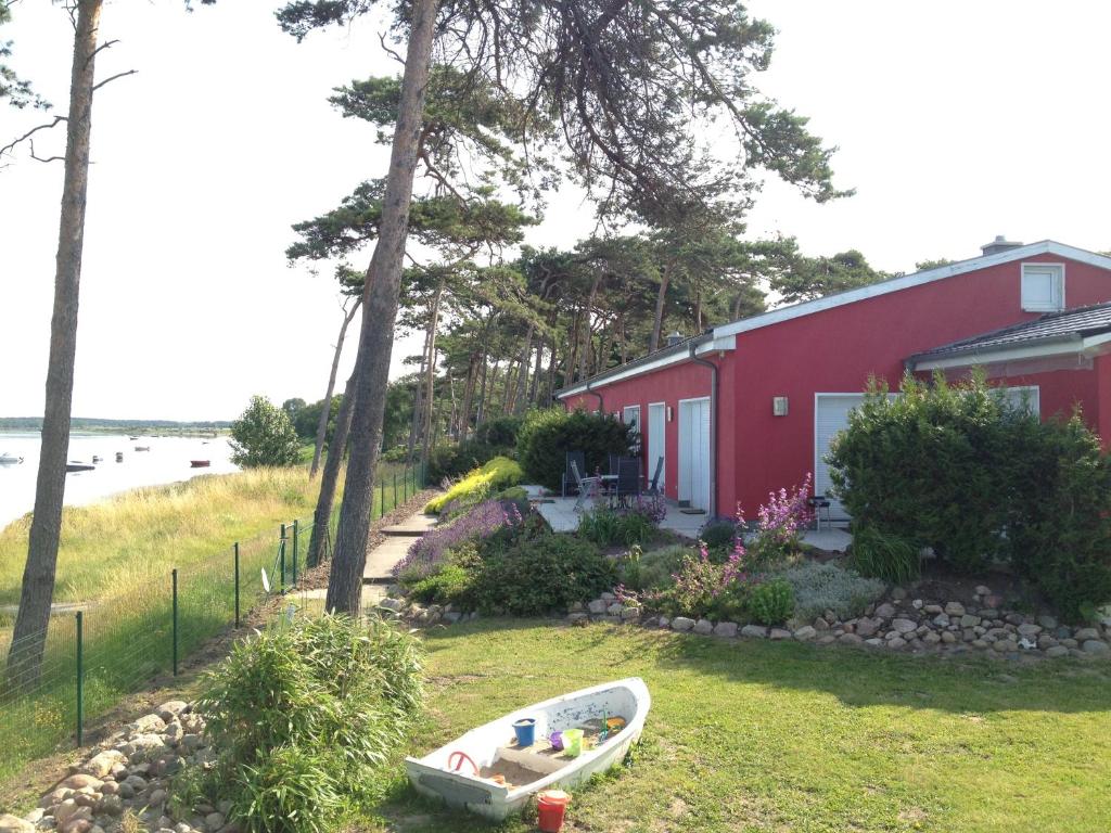 ein Boot, das auf dem Gras vor einem roten Haus sitzt in der Unterkunft Ferienwohnung Pepelow bei Rerik in Klein Strömkendorf