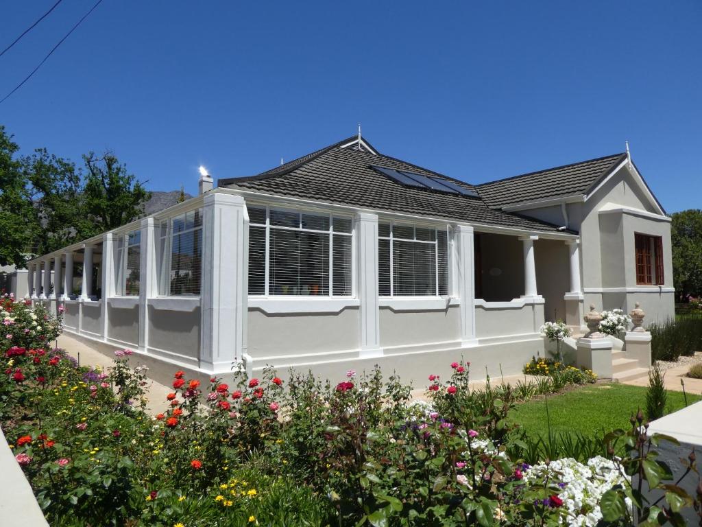 a house with a conservatory in a garden at Sorgvry - House of Guests in Barrydale