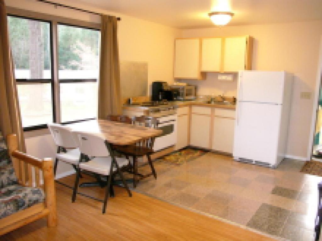 a kitchen with a table and a white refrigerator at Mountain View Lodge in Packwood