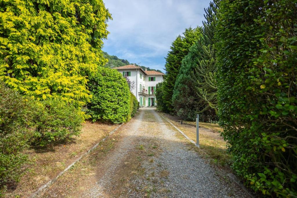 a dirt road in front of a house between trees at Lake Orta Villa Retreat in Pella