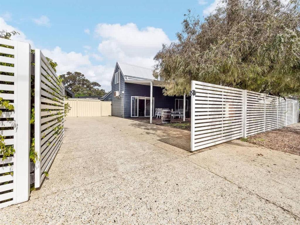 a house with a white fence and a driveway at Pepper Cottage - Easy Beachside Living Close to Town in Dunsborough