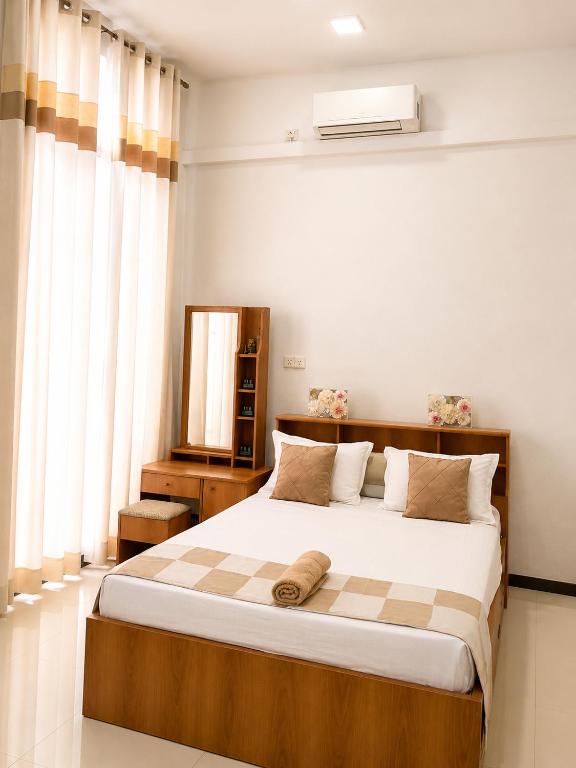 a bedroom with a large bed and a window at Ayubowan Home Stay - Kotikawatta in Angoda