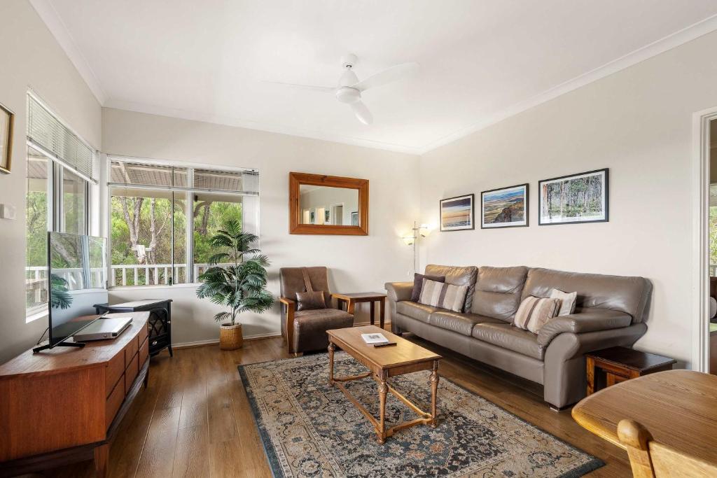 a living room with a couch and a table at Hillview - Spacious Bushland Haven with Resort Access in Yallingup